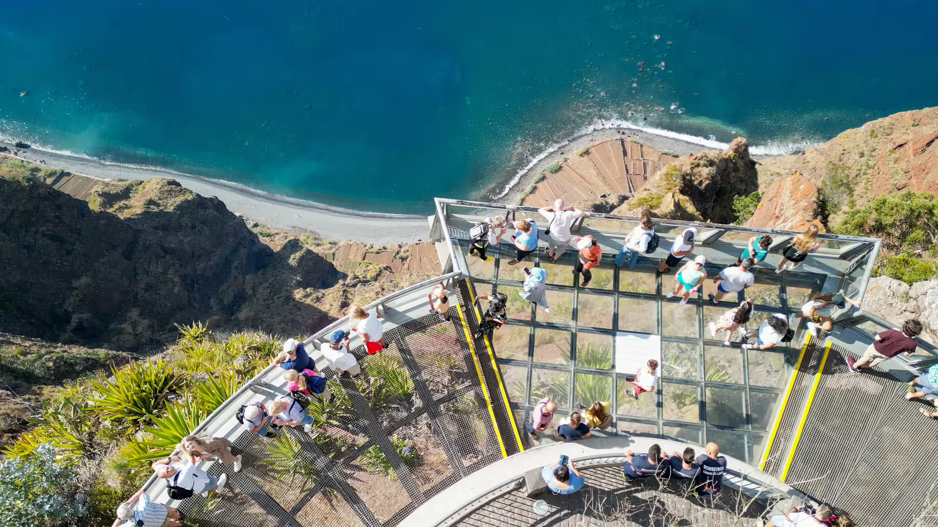 Breathtaking aerial view of Cabo Girão Skywalk with tourists enjoying panoramic ocean vistas on a full-day Madeira tour.