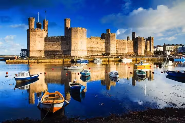 Caernarfon Castle and harbour boats on Snowdonia & The 3 Castles Tour, iconic North Wales UNESCO fortress