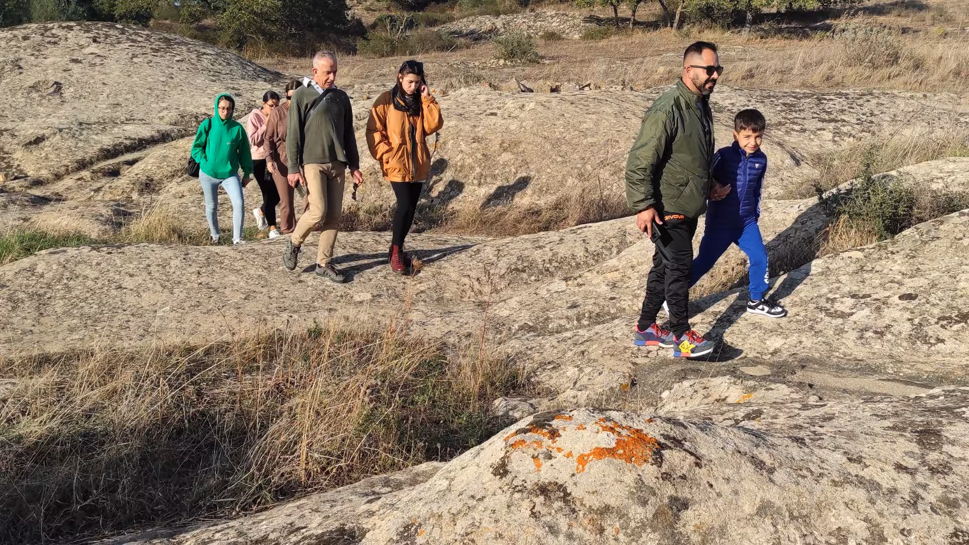 Visitors hiking on rugged terrain during the Cagliari ATV tour from Guasila, enjoying nature.