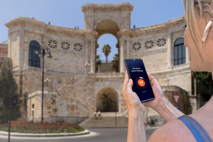 Tourist using audio guide app at Bastione Saint Remy during self-guided walking tour of Cagliari