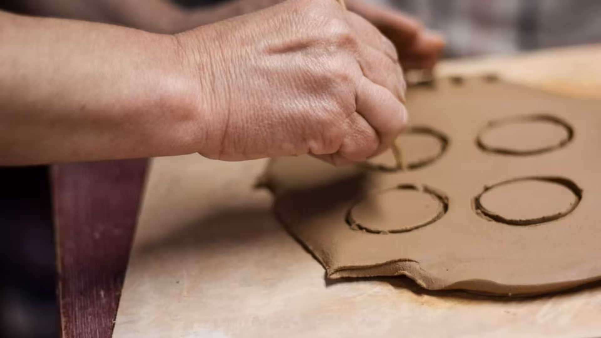 Close-up of clay being intricately carved during a Cagliari ceramics workshop, showcasing artisan skills.