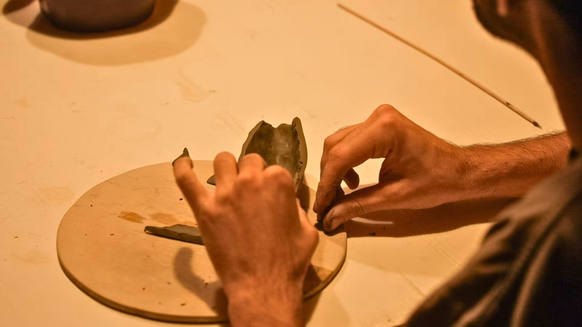 Hands crafting clay sculpture in Cagliari ceramics workshop, highlighting hands-on artistic experience.