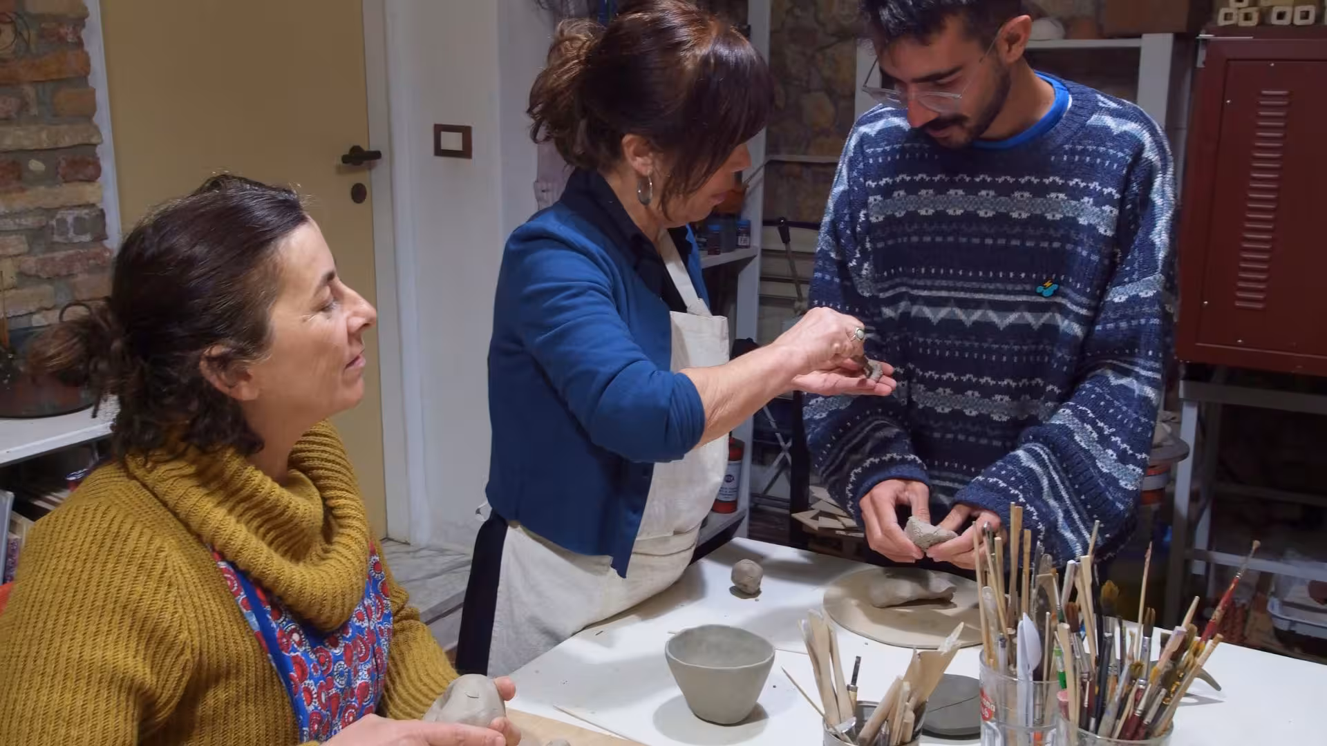 Participants engage in hands-on learning at a Cagliari ceramics workshop, crafting clay pieces with expert guidance.