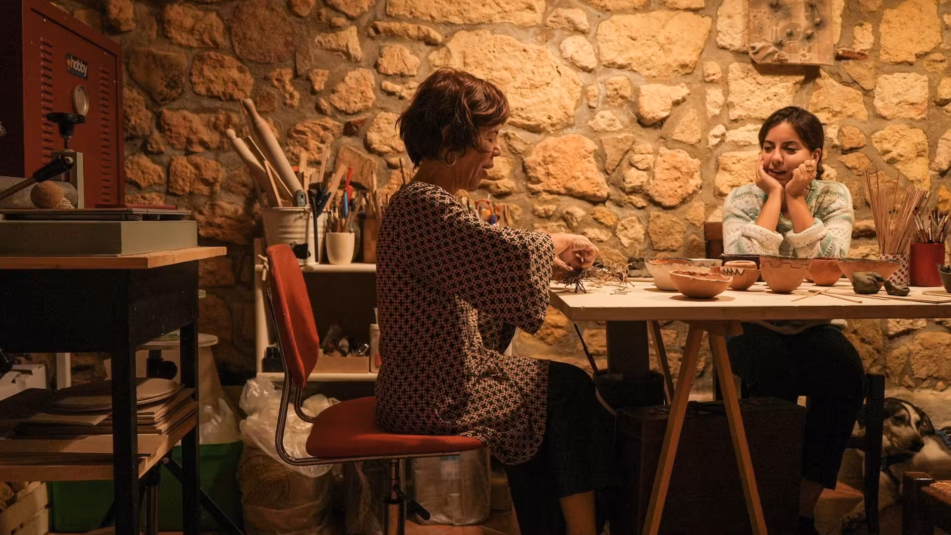 Participants engaged in a Cagliari ceramics workshop, crafting unique pottery in a rustic studio setting.