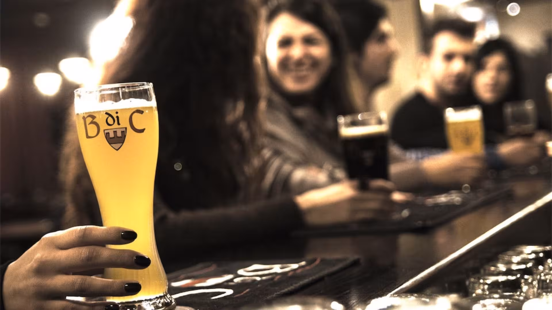 Group of friends enjoying craft beer at a bar in Cagliari, showcasing the social atmosphere of the brewery tour.