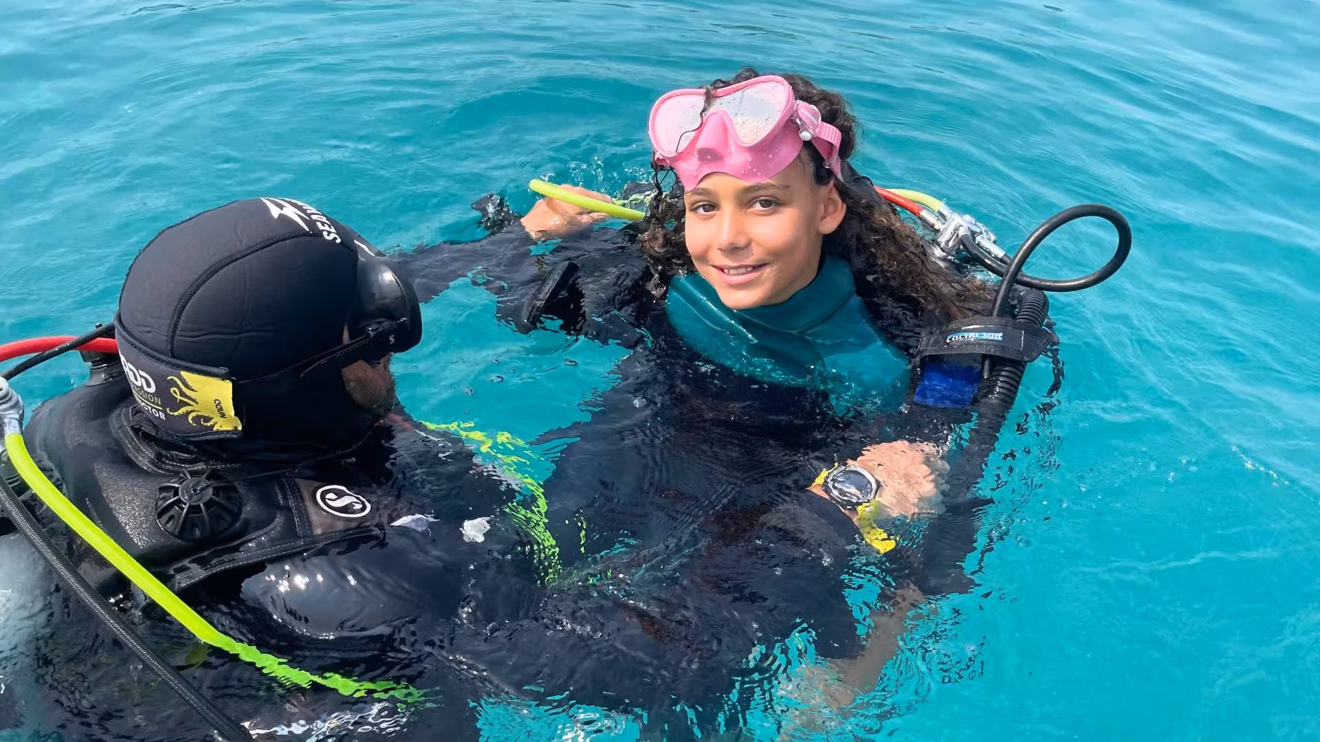 Smiling diver with guide in the clear waters of the Gulf of Angels, Cagliari, ready for an unforgettable diving experience.