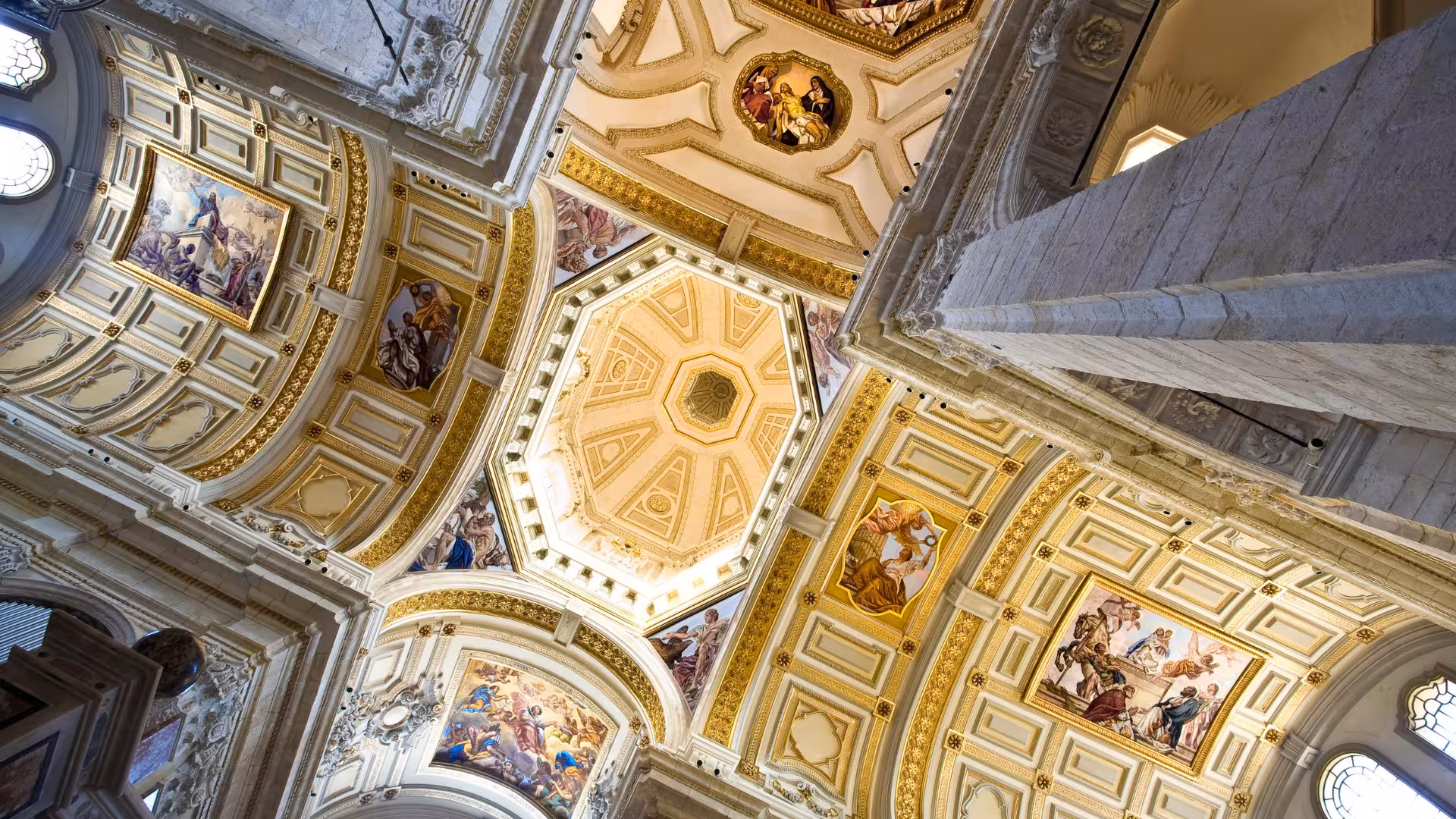 Intricate frescoes adorn the ornate ceiling of a historic building in Cagliari's tour of the historic centre.