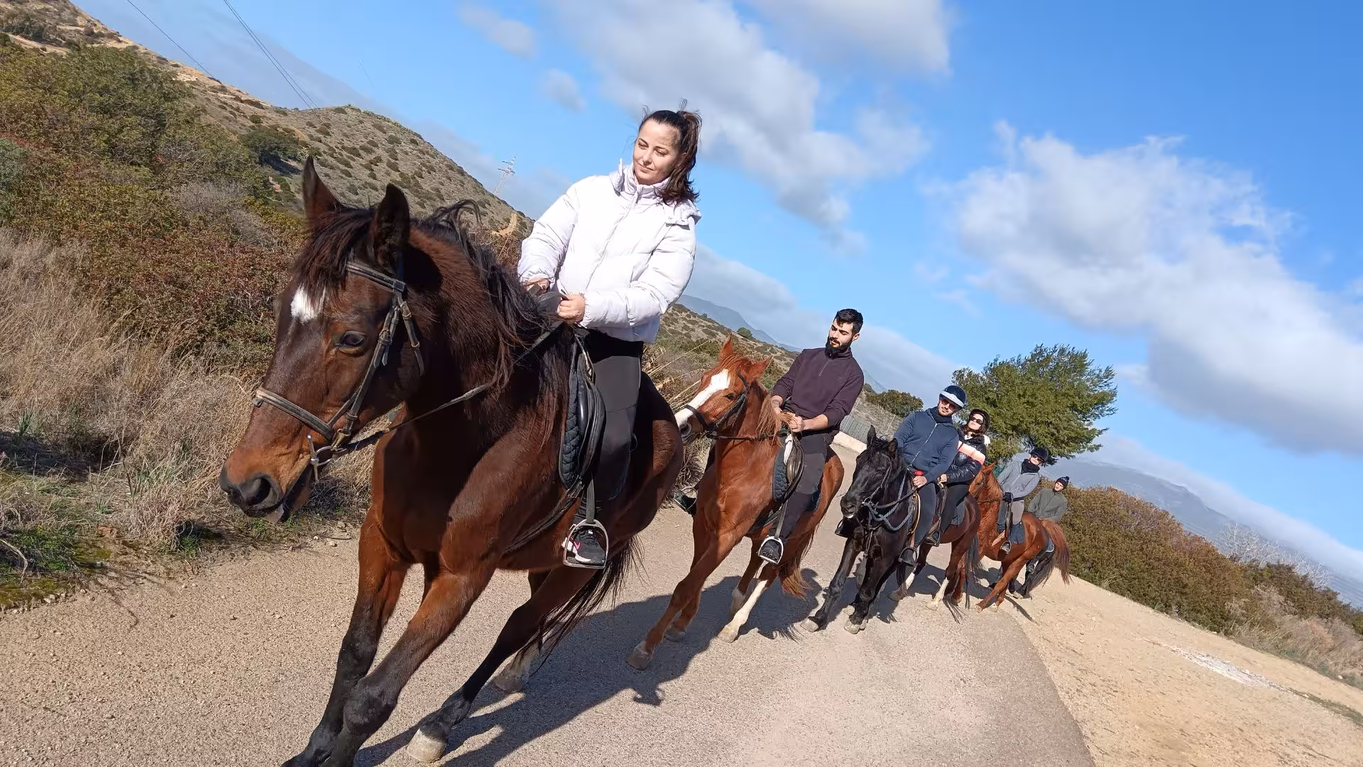 Group of riders on horseback exploring scenic trails in Cagliari under a clear blue sky.