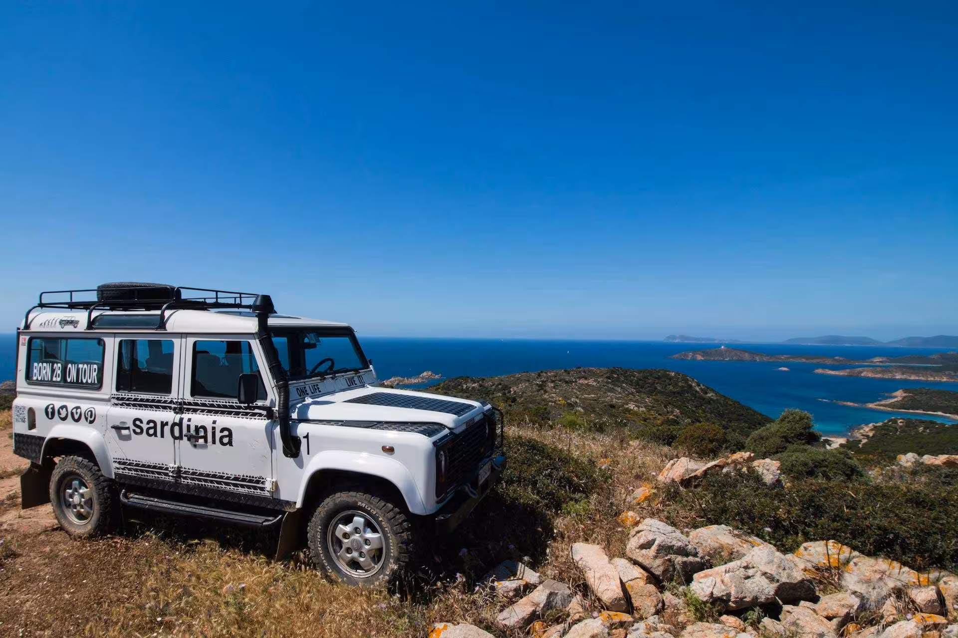 Jeep parked on a hill overlooking the stunning coastal view of Villasimius during a Cagliari jeep tour.