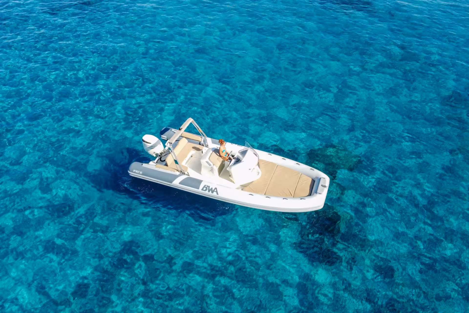 Top view of a RIB boat navigating the stunning azure waters around Cagliari, perfect for an adventurous sea tour.