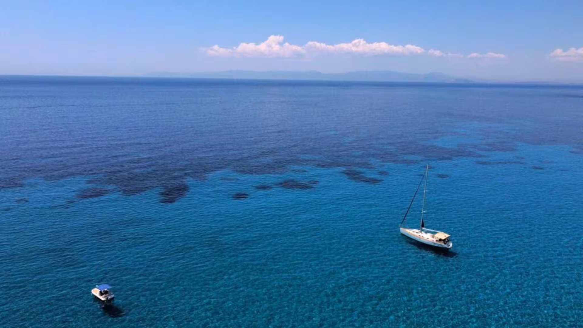 Aerial view of a sailing boat on the serene blue waters of Cagliari during a scenic 3-hour sailing tour.