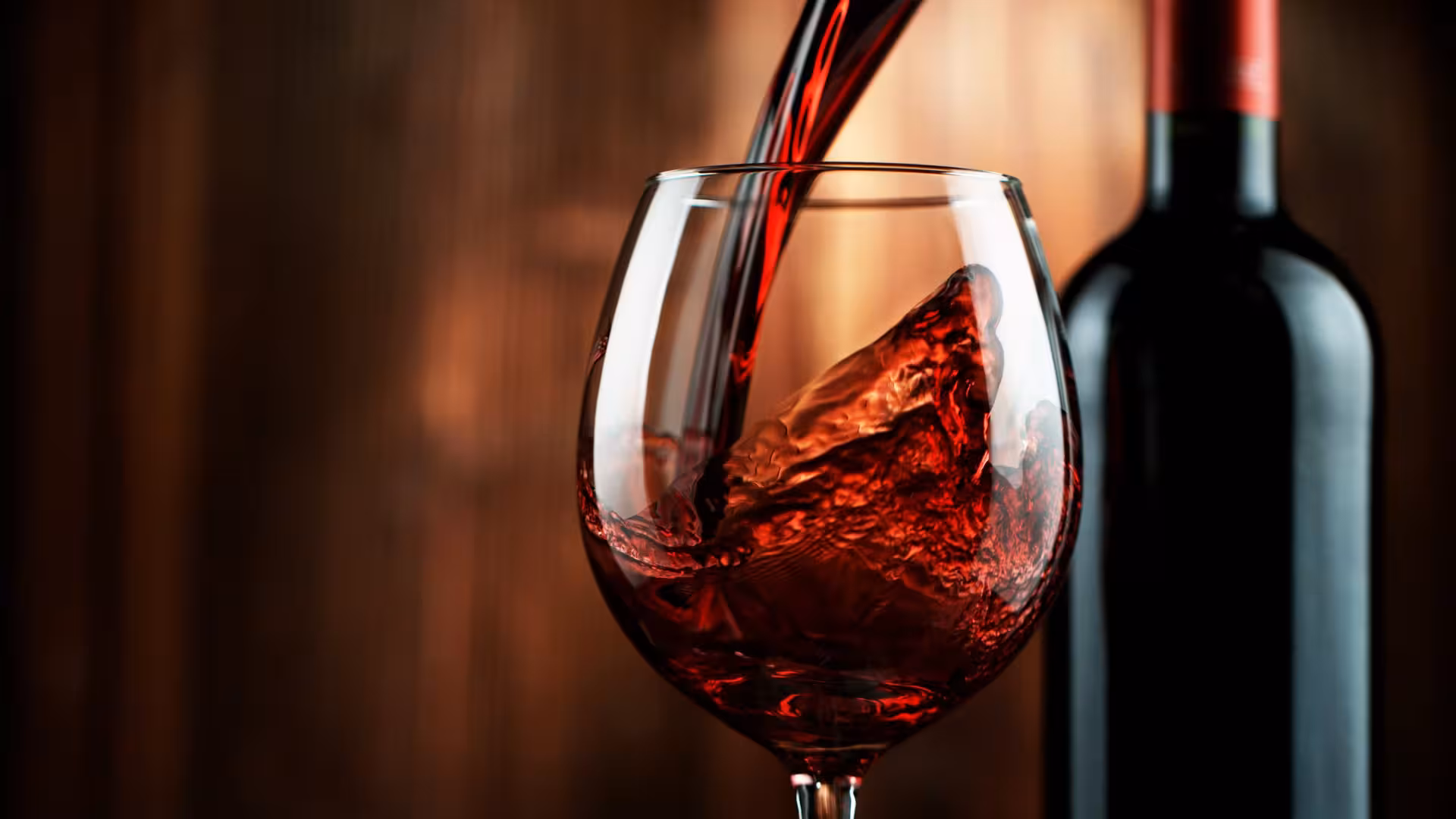 Pouring rich red wine into a glass at a Cagliari winery, perfect for wine enthusiasts visiting Sardinia.