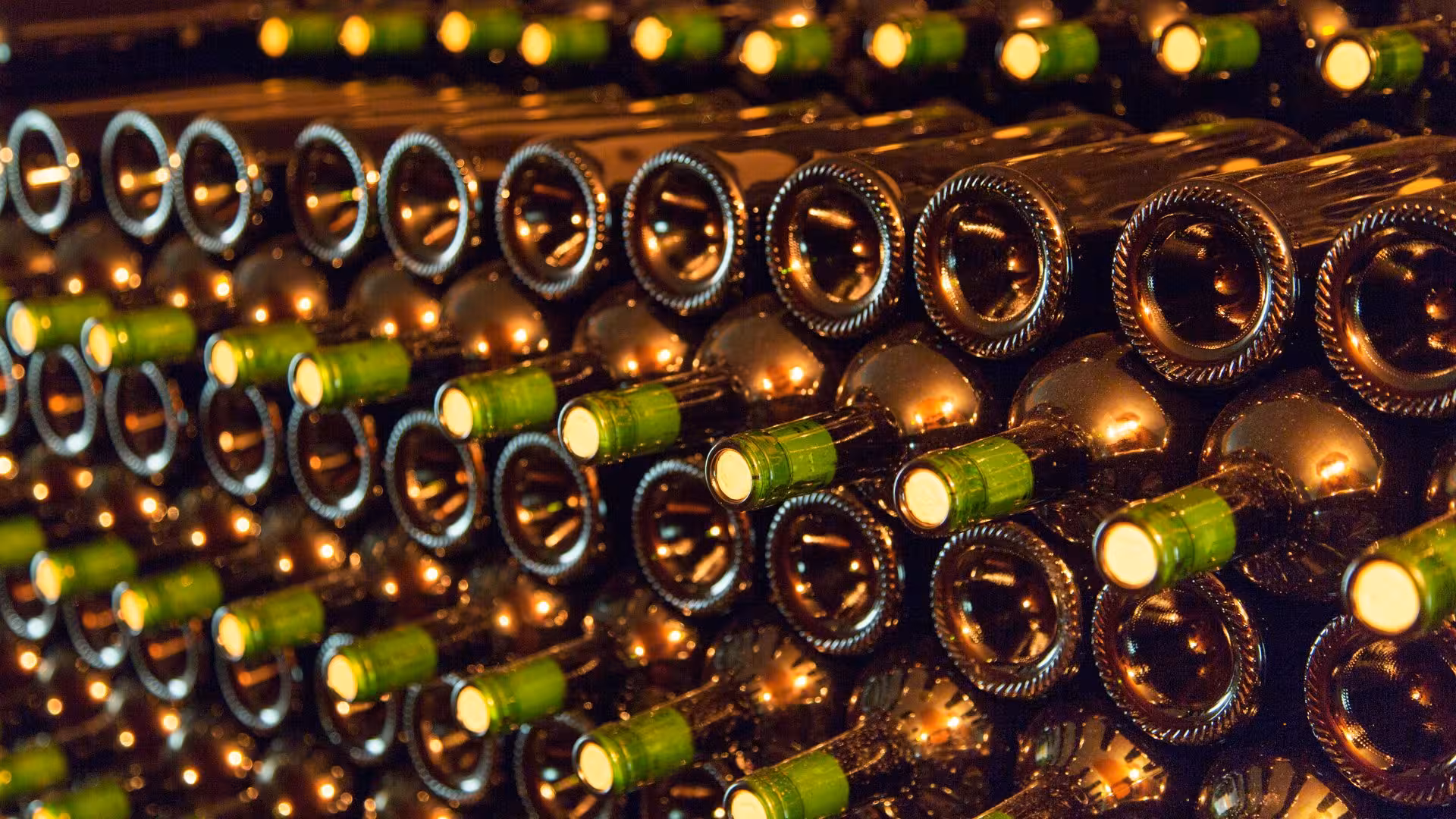 Stacked wine bottles in a Cagliari winery, highlighting a rich heritage of wine making and tasting tours.