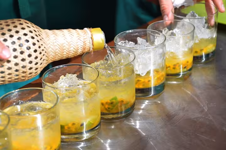 Refreshing caipirinhas being prepared with ice and passion fruit, a highlight of our Rio seafood cooking class experience.