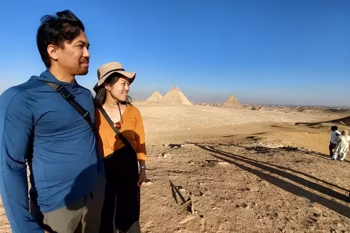 Couple enjoying Giza Plateau viewpoint on Cairo Airport private transfer tour to Pyramids, Egyptian Museum and Coptic Cairo