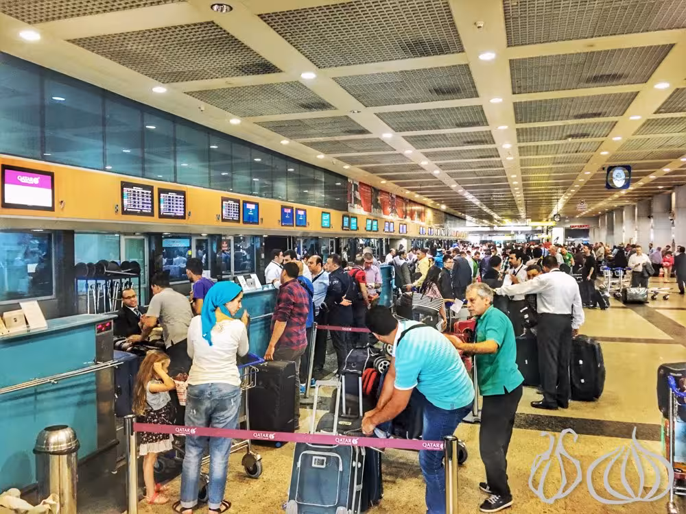 Busy Cairo Airport arrivals hall with travelers and luggage, highlighting private meet-and-greet transfer to Cairo hotel