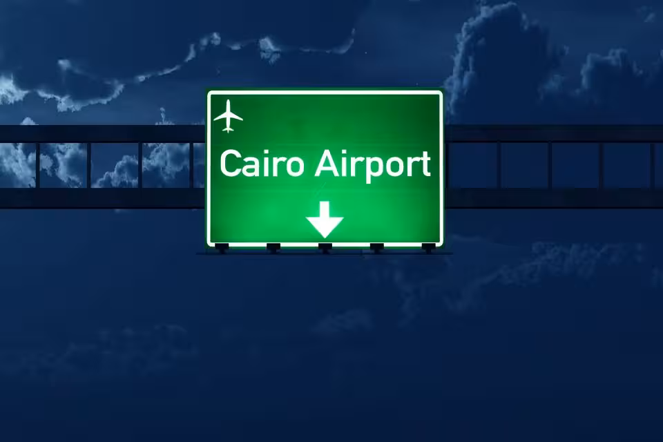 Green road sign pointing to Cairo Airport, representing private airport transfer for arrivals and departures
