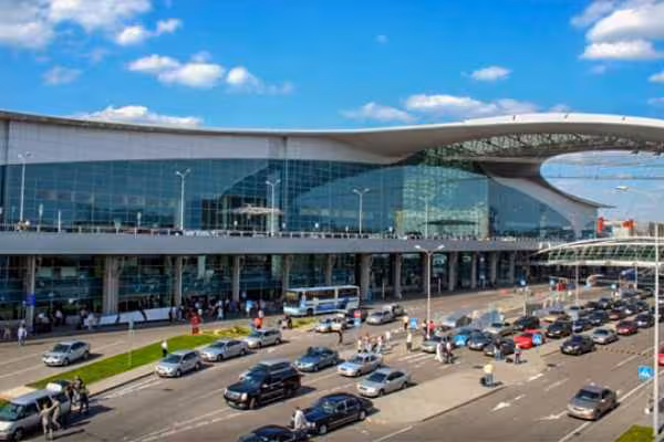 Exterior of Cairo International Airport terminal with traffic lanes, ideal for private arrival transfer to Cairo hotels
