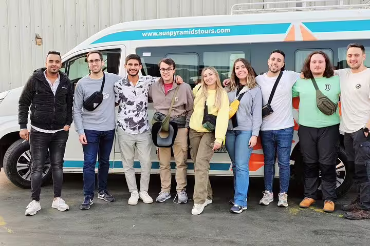 Happy travelers posing by private Cairo Airport transfer van, reliable pickup and drop-off service in Cairo