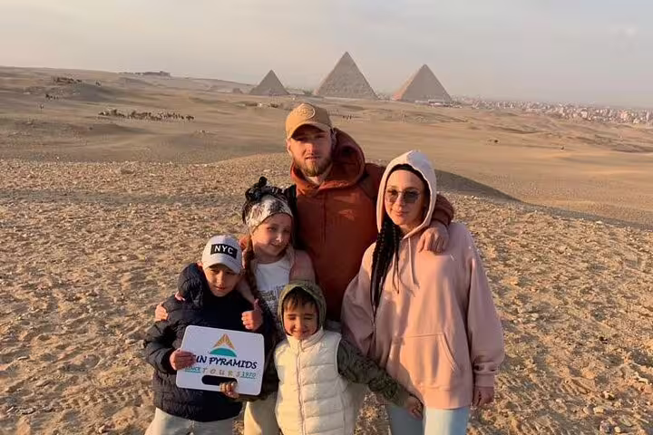 Family photo at Giza Pyramids viewpoint during 2-day Cairo and Alexandria tour from Luxor with flights
