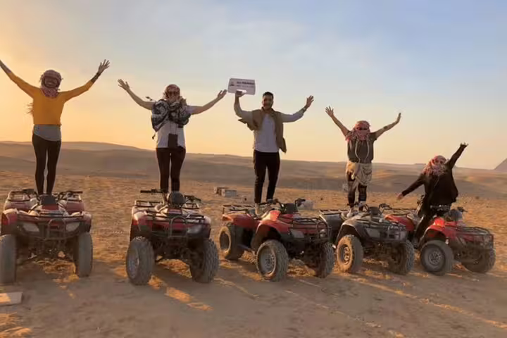 Group on ATVs in the desert at sunset, adventure add-on for private 2-day Cairo pyramids tour