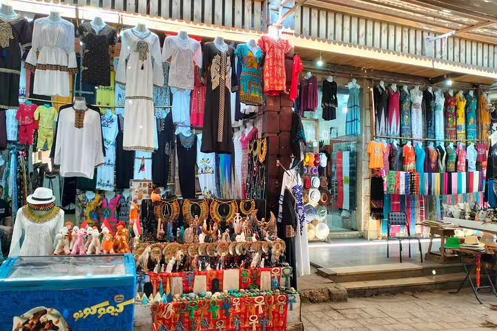 Colorful Cairo bazaar stall with Egyptian souvenirs and traditional clothing on an 8-day Egypt pyramids cruise tour