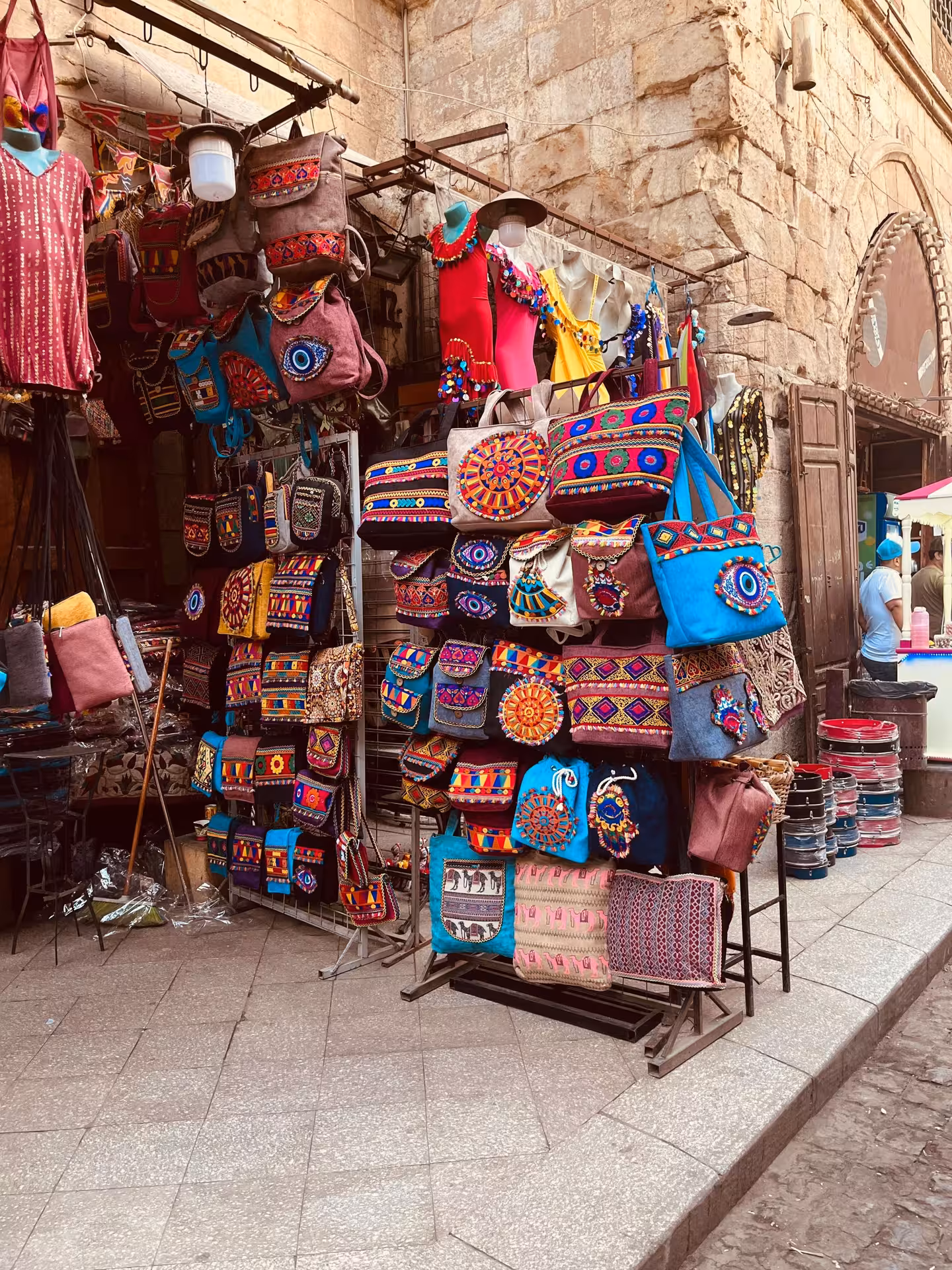 Colorful embroidered bags and backpacks displayed at a Cairo bazaar market stall