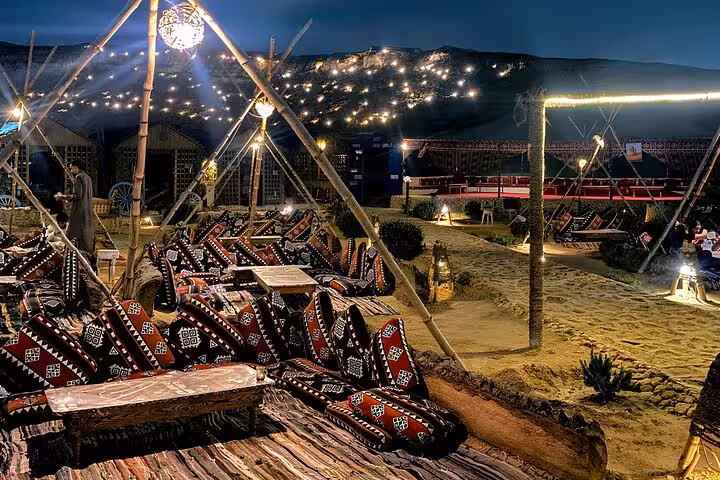 Cozy Bedouin lounge at night in Giza desert camp with lanterns, VIP Arabian Night dinner and show setting