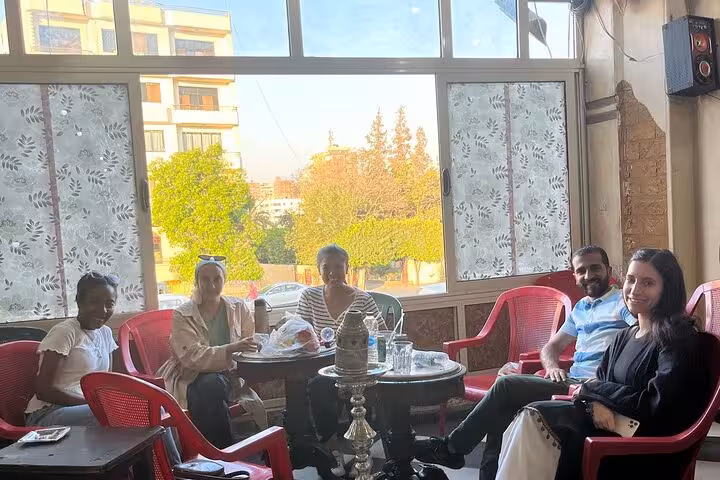 Travelers relax at a local Cairo cafe with shisha, part of a hidden gems culture and cuisine tour