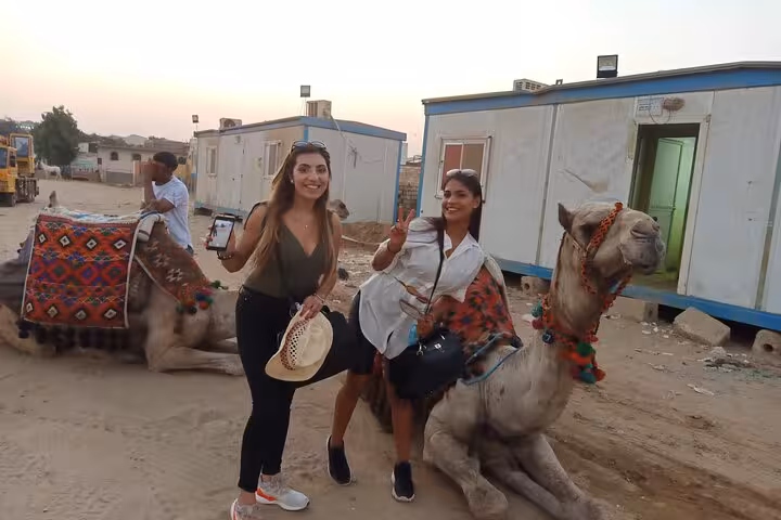 Guests pose with decorated camels during Cairo camel ride tour with lunch, quad biking and shopping stop