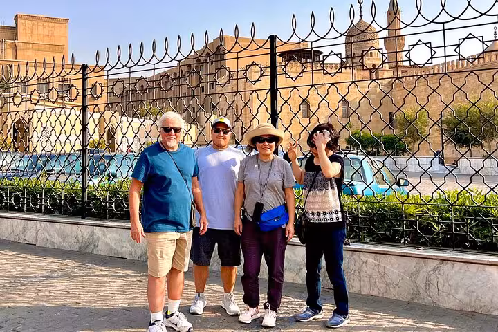 Travelers posing by historic Cairo citadel walls, a stop on private 3-day Cairo Giza Alexandria tour
