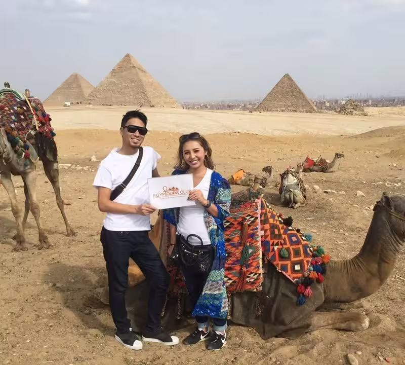Private Cairo day tour by air from Sharm El Sheikh with travelers and camels at Giza Pyramids