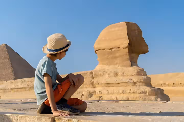 Traveler watching the Great Sphinx of Giza on a Cairo day tour by plane from Marsa Alam, pyramids nearby