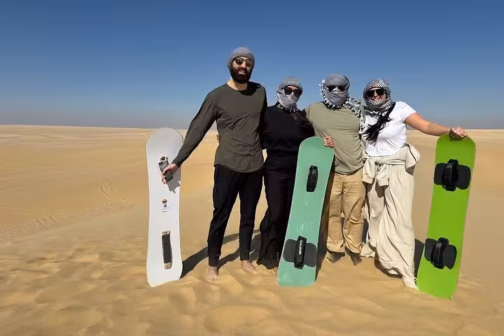 Group posing with sandboards on Fayoum Oasis dunes, Cairo day trip with dune thrills and Magic Lake views