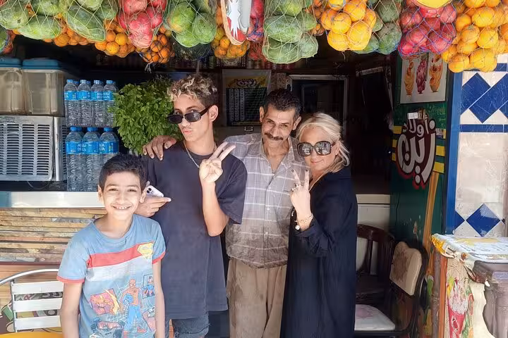 Private Cairo food tour photo with locals at a juice shop, fresh fruit display and market atmosphere
