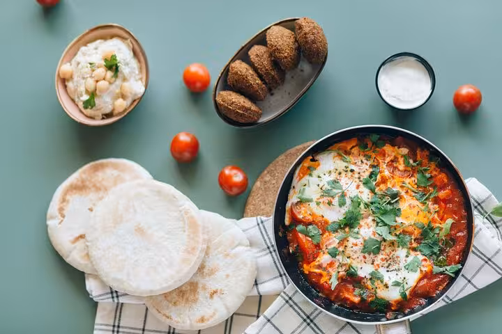 Delicious Cairo food tour featuring shakshuka, pita, falafel, and hummus, highlighting authentic Egyptian flavors.