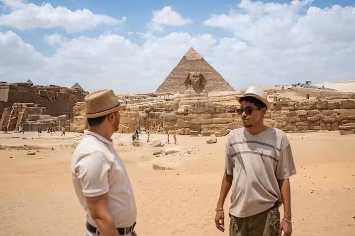 Tour guide and traveler at Giza Plateau with Great Sphinx and pyramid on Cairo private day trip