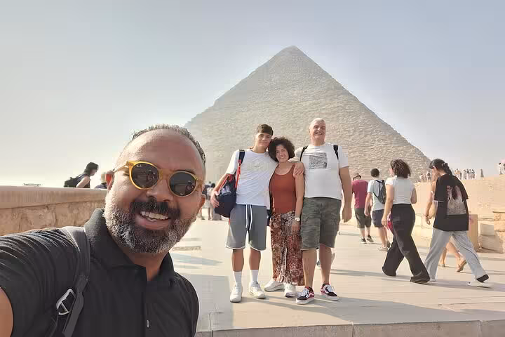 Group selfie at the Great Pyramid on a VIP Giza & GEM tour featuring Pyramids, Sphinx, camel ride and felucca