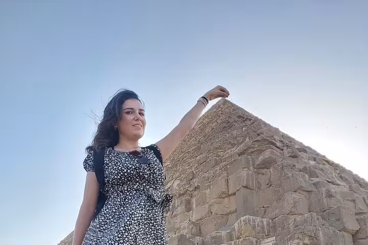 Traveler posing with the Great Pyramid of Giza on a Cairo private trip, classic perspective photo in bright sky