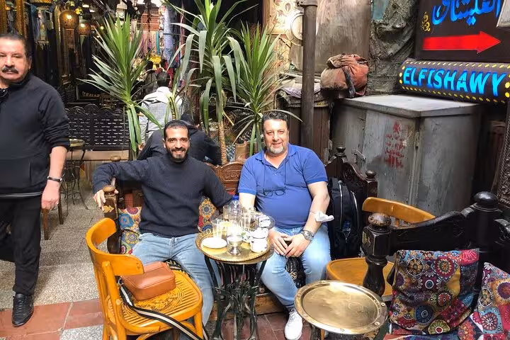 Travelers enjoy Egyptian tea at a hidden Cairo alley cafe, local culture stop on cuisine and Nile felucca tour