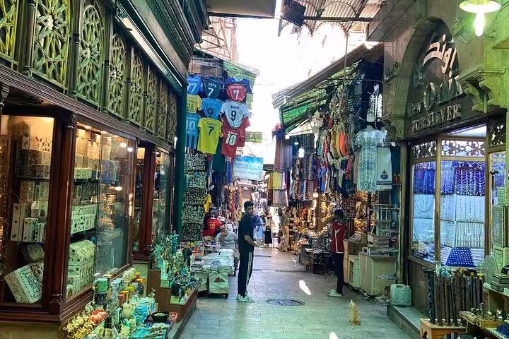 Narrow alley in Cairo Khan el Khalili bazaar with souvenir shops, jerseys and crafts on a shopping tour