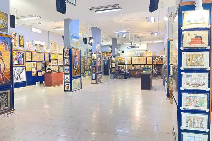 Wide view of a Cairo Khan el Khalili gallery shop filled with framed artwork and souvenirs on shopping tour