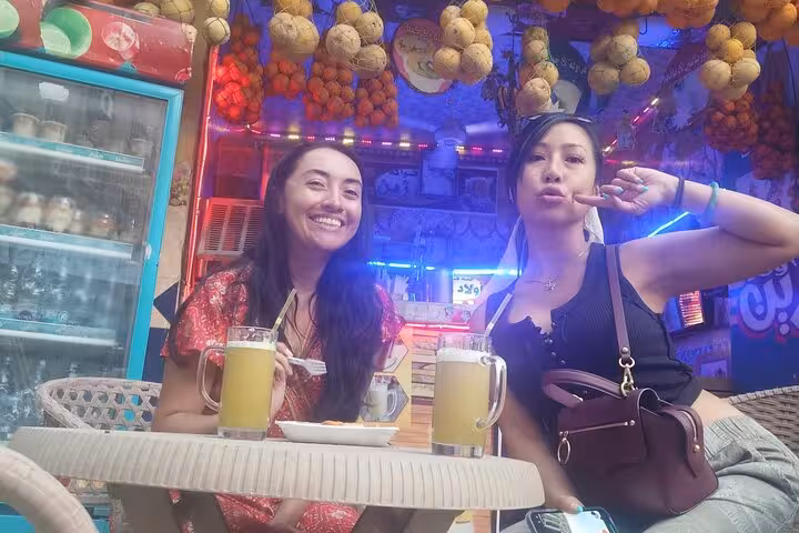 Friends sipping drinks at a Cairo market café during Khan el Khalili shopping tour with traditional koshary lunch