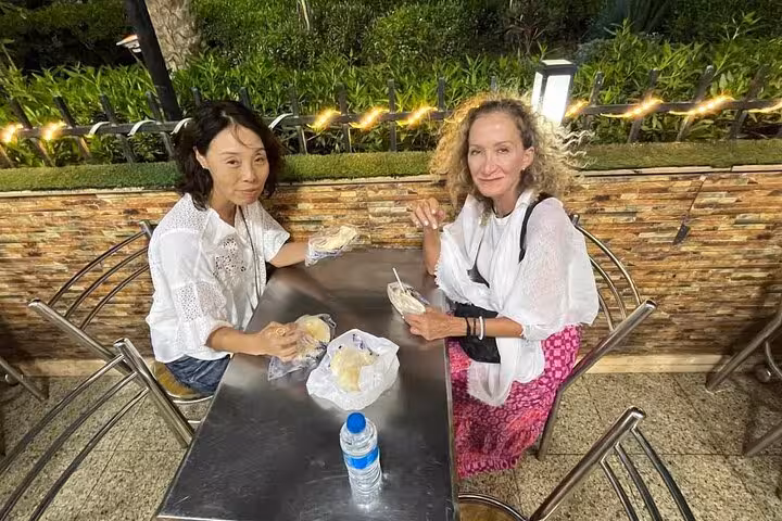 Travelers enjoy Egyptian koshary lunch at outdoor café during Cairo Khan el Khalili Market shopping tour