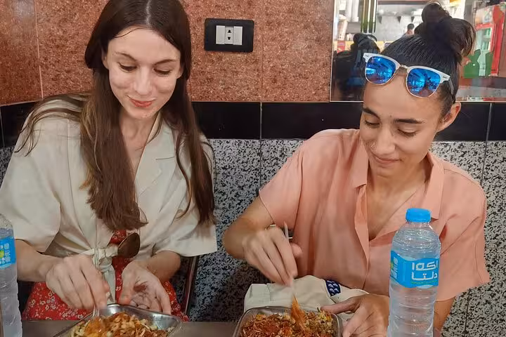 Travelers enjoying koshary lunch in Cairo, a tasty stop on the Khan el Khalili market shopping tour