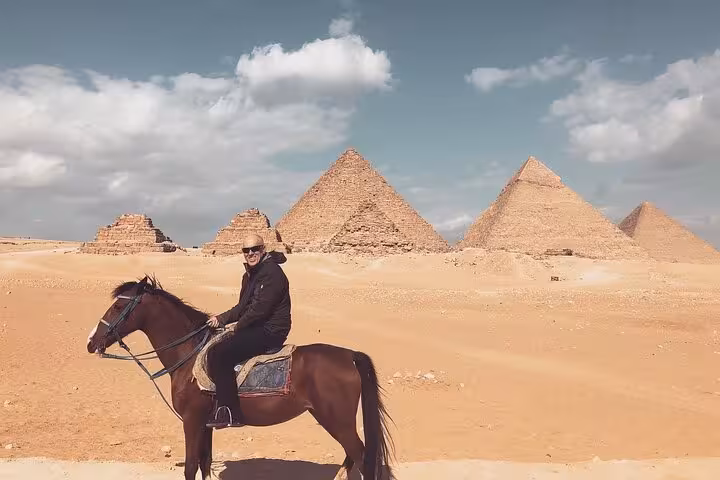 Horseback ride in the desert with Giza Pyramids backdrop on a Cairo airport layover tour from Cairo Airport