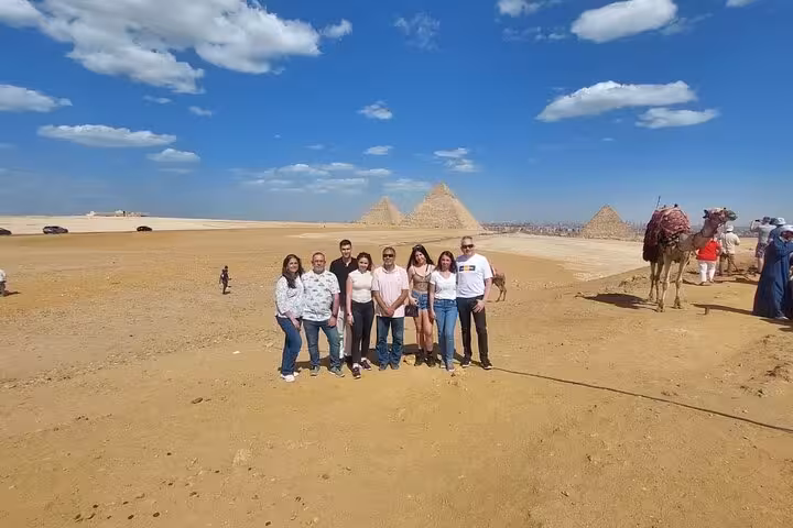 Tour group photo in Giza desert with pyramids and camel, Cairo Airport layover tour to Giza and GEM