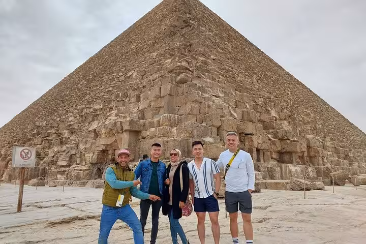 Small group photo at Great Pyramid of Giza on Cairo airport layover tour, guided stop before Grand Egyptian Museum