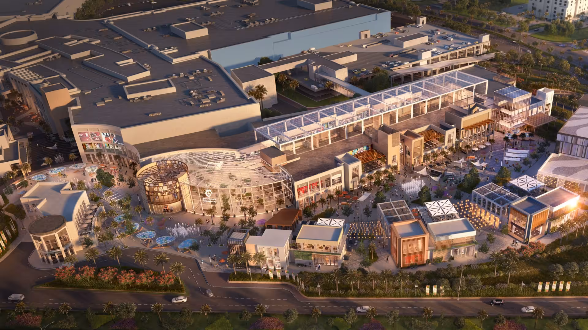 Aerial view of a modern Cairo shopping mall complex with open-air plazas, palm trees, and glass architecture at dusk