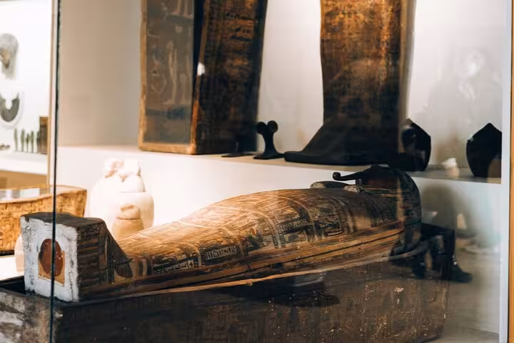 Ancient Egyptian wooden sarcophagus display at Cairo Museum on full-day tour from Hurghada